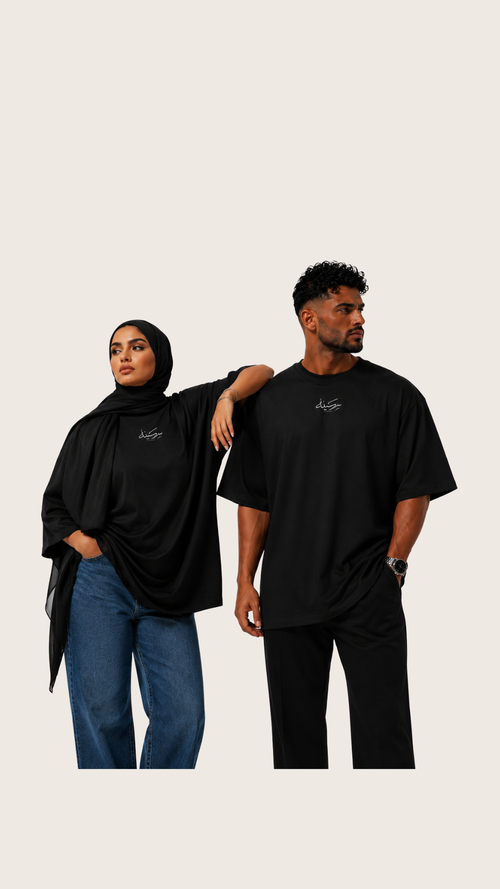 T-shirt oversize noir HMA « سكينة » Sakina porté par deux modèles, vue rapprochée